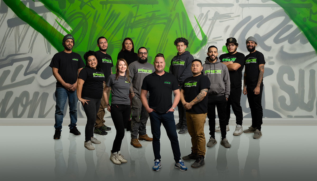 Corporate team portrait photographed in front of a large branded mural